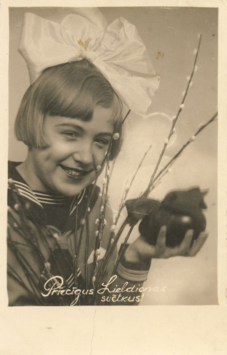 2.	Pastkarte "Priecīgus Lieldienas svētkus!" (Meitene ar pūpoliem un olu rokās.) Valmieras fotogrāfa Vilhelma Vektera darbnīca. Pasta aprite 1935. Privātkolekcija. Skenējums